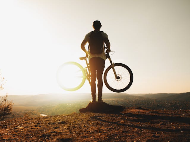 person with a bike on a large hill